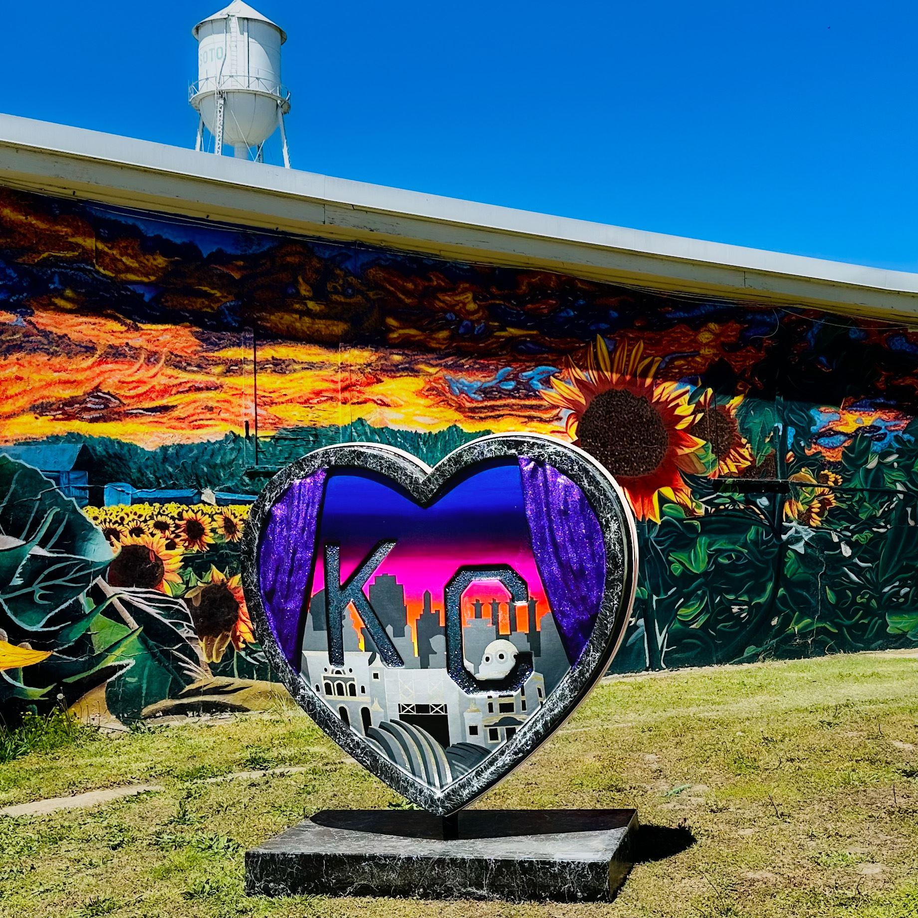 Parade of Hearts heart in front of the sunflower mural and water tower